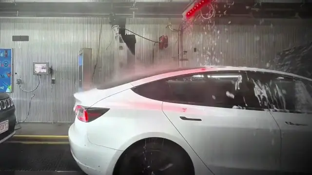 CleanTrak robotic prep arm washing a car