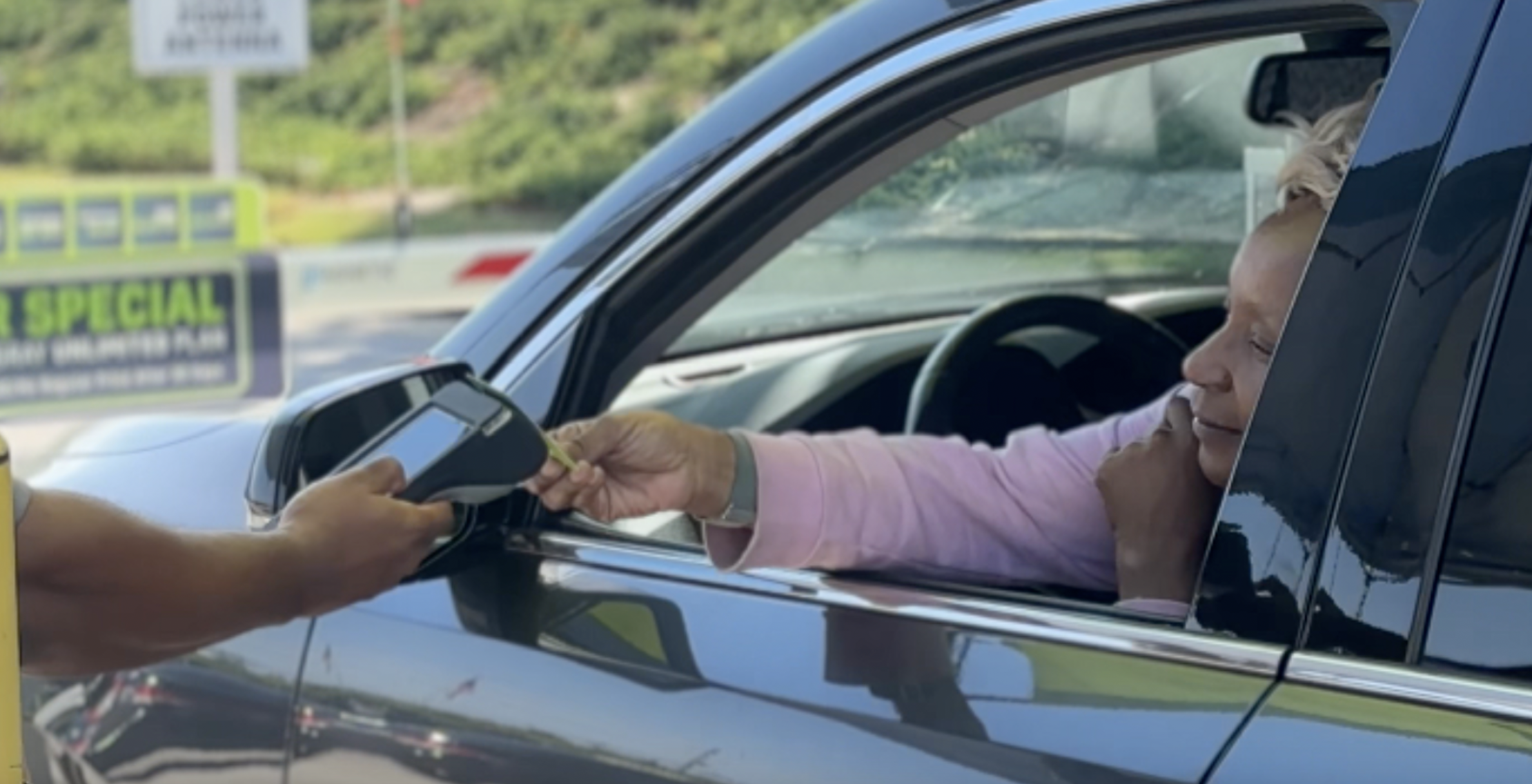 Car wash attendant using tablet POS to serve customer in vehicle